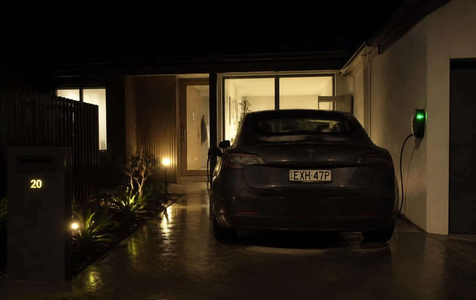 Electric car charging overnight in the driveway of a modern Australian home
